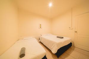 two beds in a small room with a door at GAO Phala Beachfront Hostel in Ban Phala