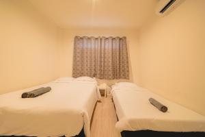 two beds in a room with a window at GAO Phala Beachfront Hostel in Ban Phala