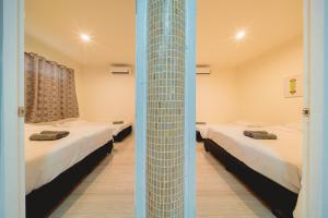 a room with two beds and a tall glass column at GAO Phala Beachfront Hostel in Ban Phala