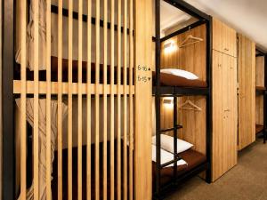 a room with a bunk bed with wooden walls at Namba Guesthouse HIVE in Osaka