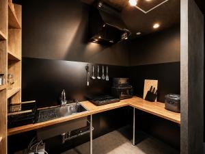 a kitchen with a sink and a counter top at Namba Guesthouse HIVE in Osaka