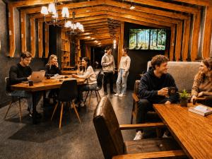 a group of people sitting at tables in a restaurant at Namba Guesthouse HIVE in Osaka