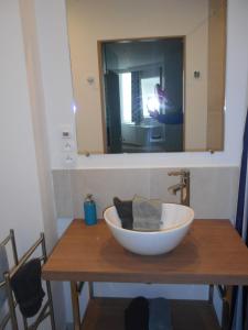 a large white bowl on a wooden table with a mirror at Bed aan zee Kabine7 in Koksijde