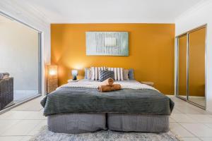 a teddy bear sitting on a bed in a bedroom at Lagoons Resort Studio 64 in Agnes Water +14 photos