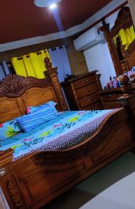 a bedroom with a large wooden bed with blue sheets at Villa panamericana in El Seis