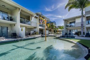 a swimming pool in front of a building at Lagoons Resort Apartment 63 in Agnes Water