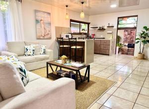 a living room with two couches and a kitchen at Retiro Arenal in Fortuna