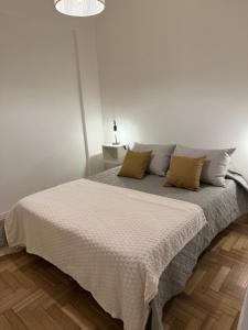 a white bedroom with a large bed with pillows at Colón 2 in Mar del Plata