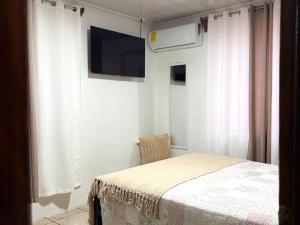 a bedroom with a bed and a television on a wall at Retiro Arenal in Fortuna