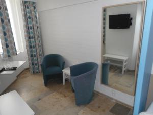 a room with a mirror and a chair and a tv at Bed aan zee Kabine7 in Koksijde