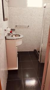 a bathroom with a sink and a tiled floor at Mí cielo in Huerta Grande