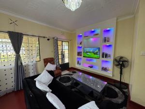 a living room with a couch and a tv at The Mimaced Homes in Homa Bay