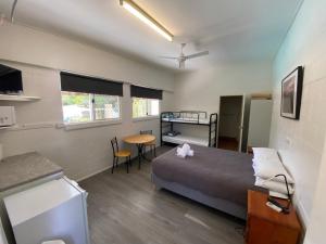 a room with a bed and a desk and a table at Bundaberg Park Village in Bundaberg