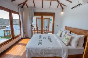 a bedroom with a bed with a sign on it at Indigo Blue Ceningan in Nusa Lembongan +144 photos