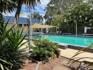 a swimming pool in a resort with a yellow canopy at Bundaberg Park Village in Bundaberg