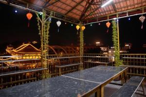 a pavilion with tables and lanterns at night at Thong dong homestay&villas in Quỳnh Lưu