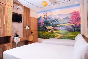 a bedroom with two beds and a painting of a mountain at Thong dong homestay&villas in Quỳnh Lưu