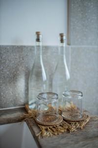 two glass jars sitting on a wooden table with bottles at Indigo Blue Ceningan in Nusa Lembongan