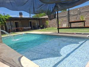 a swimming pool in a yard with a house at Finca El Algarrobo, confort y excelente ubicación in Santiago del Estero
