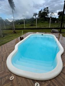 a large swimming pool on a wooden deck at Refúgio Mix Pousada com 3 suítes e 9 camas in Vilhena