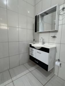 a white bathroom with a sink and a mirror at Refúgio Mix Pousada com 3 suítes e 9 camas in Vilhena