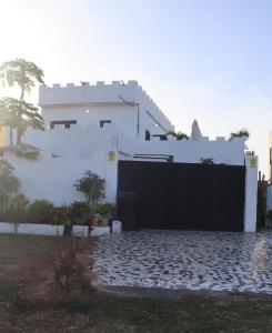 a white house with a black gate at butterfly lodge in Brufut +2 photos