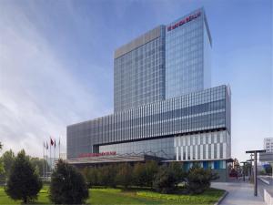 a tall building with a sign on the side of it at Wanda Realm Beijing in Beijing