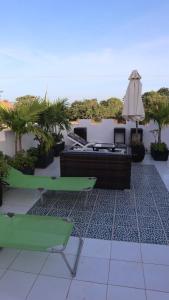 a patio with a couch and a table and an umbrella at butterfly lodge in Brufut