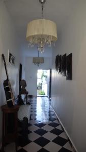 a hallway with a chandelier and a checkered floor at butterfly lodge in Brufut