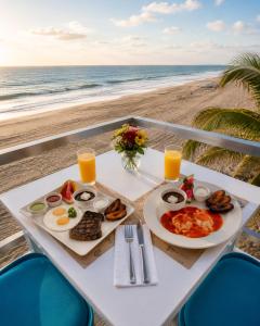 a table with breakfast food on the beach at Hotel Playa Paraíso in Monterrico