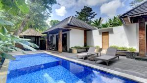 a villa with a swimming pool and a house at Villa Maeni in Munggu