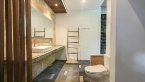 a bathroom with a white toilet and a sink at Villa Maeni in Munggu +8 photos
