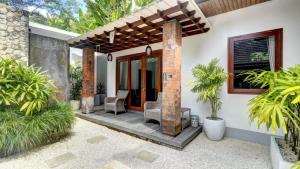 a patio of a house with chairs and plants at Villa Maeni in Munggu
