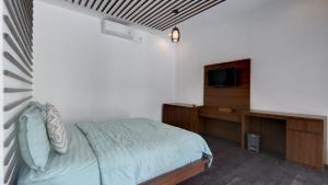 a bedroom with a bed and a flat screen tv at Villa Maeni in Munggu