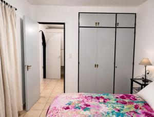 a bedroom with white cabinets and a bed with a floral bedspread at Peatonal y San Martin in Mendoza