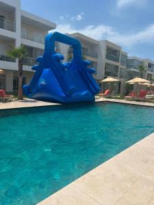 a blue slide in the middle of a swimming pool at Escapade à Sidi Rahal in Sidi Rahal