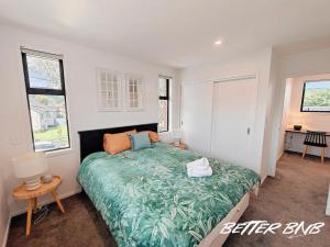 a bedroom with a bed with a green comforter at Quiet Haven Retreat | Cozy Modern Townhouse in Lower Hutt