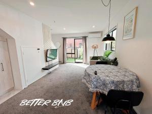a living room with a table and a couch at Quiet Haven Retreat | Cozy Modern Townhouse in Lower Hutt