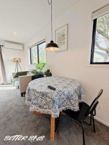 a living room with a table and a couch at Quiet Haven Retreat | Cozy Modern Townhouse in Lower Hutt