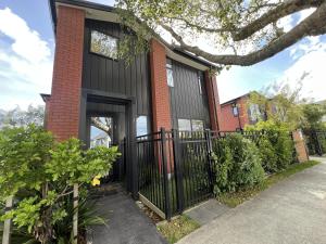a home with black siding and a black gate at Quiet Haven Retreat | Cozy Modern Townhouse in Lower Hutt