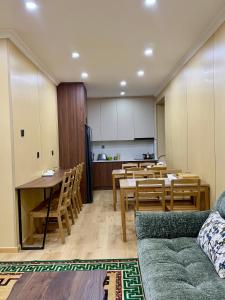 ein Wohnzimmer mit Sofa und Tischen und eine Küche in der Unterkunft Sunpath Mongolia Tour & Hostel in Ulaanbaatar