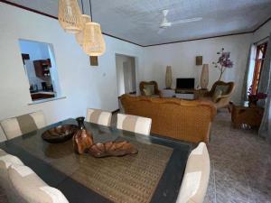 a living room with a table and a couch at Orchid Sunset Guest House in Baie Lazare Mahé