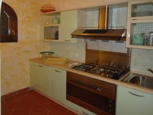 una cucina con piano cottura e lavandino di Villa Agosto a Stintino