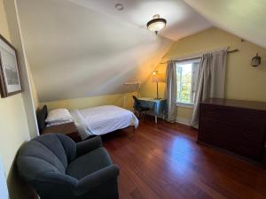 a bedroom with a bed and a chair and a window at Van Guesthouse in Vancouver