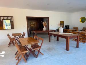 a living room with wooden tables and chairs at Pousada Santorini Guararema in Guararema