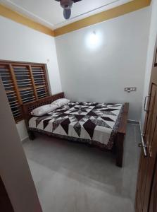 a bedroom with a bed with a black and white quilt at Tranquil Breeze Stay in Napoklu