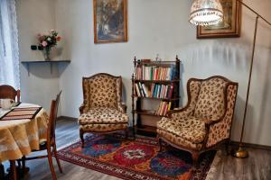 two chairs and a book shelf in a living room at Flaneur in Turin