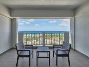 a balcony with a table and chairs and a view of the ocean at 恩納マリンビューパレス in Onna