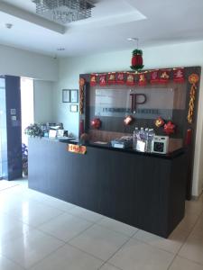 a restaurant with a black counter with a reception desk at Premierz Hotel in Labuan