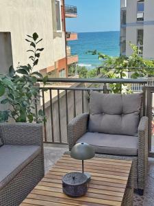 a patio with two chairs and a table and the ocean at Nicola`s Apartment in Sozopol
